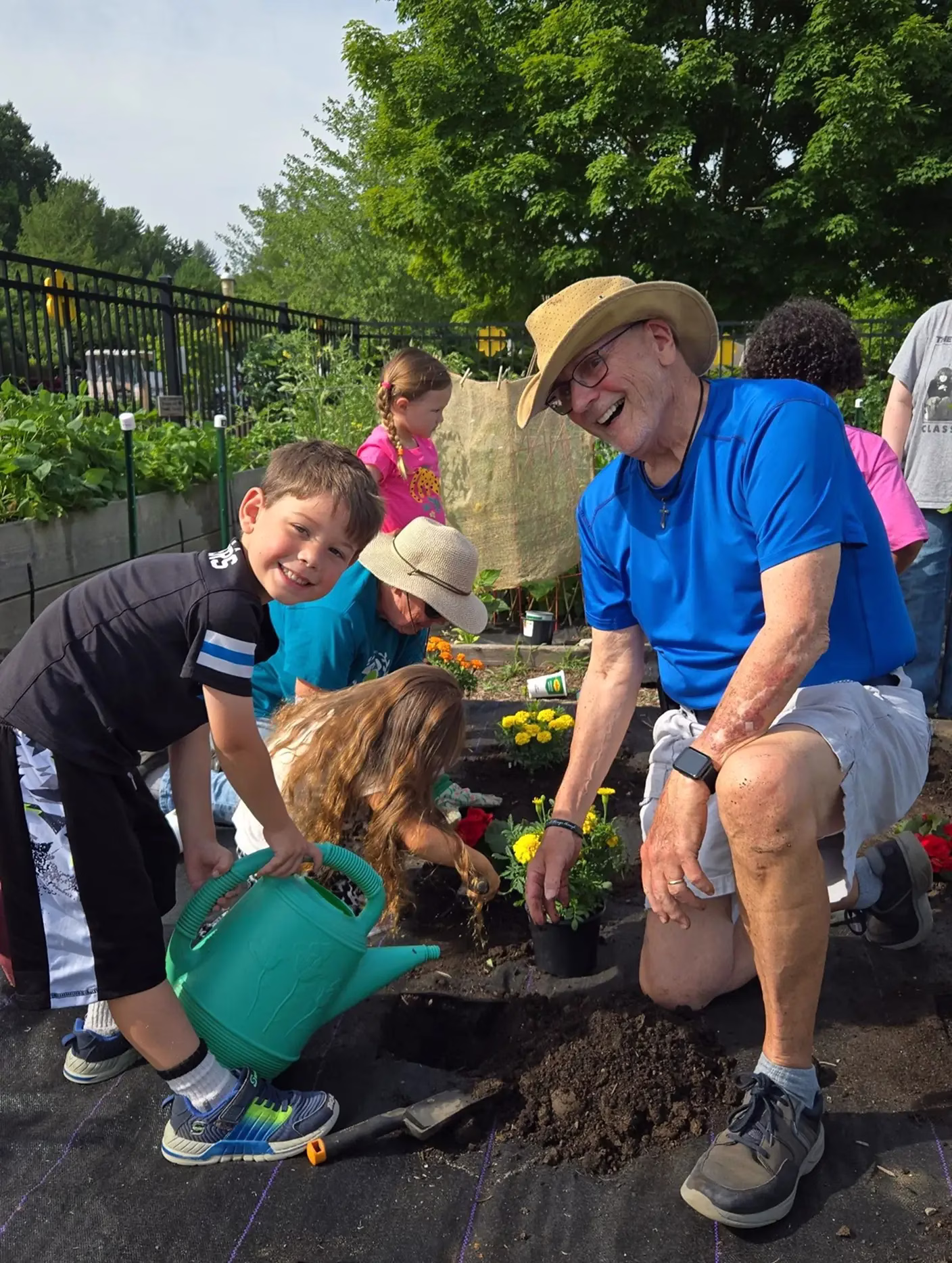 Man and children planting flowers