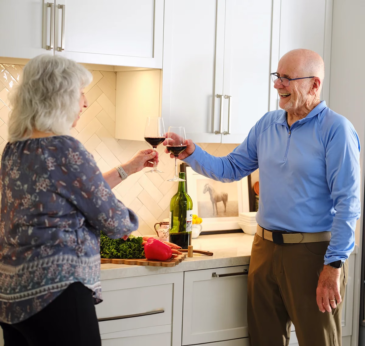Man and woman in kitchen with wine glasses