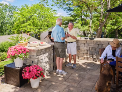 Two men grilling food outside conversing