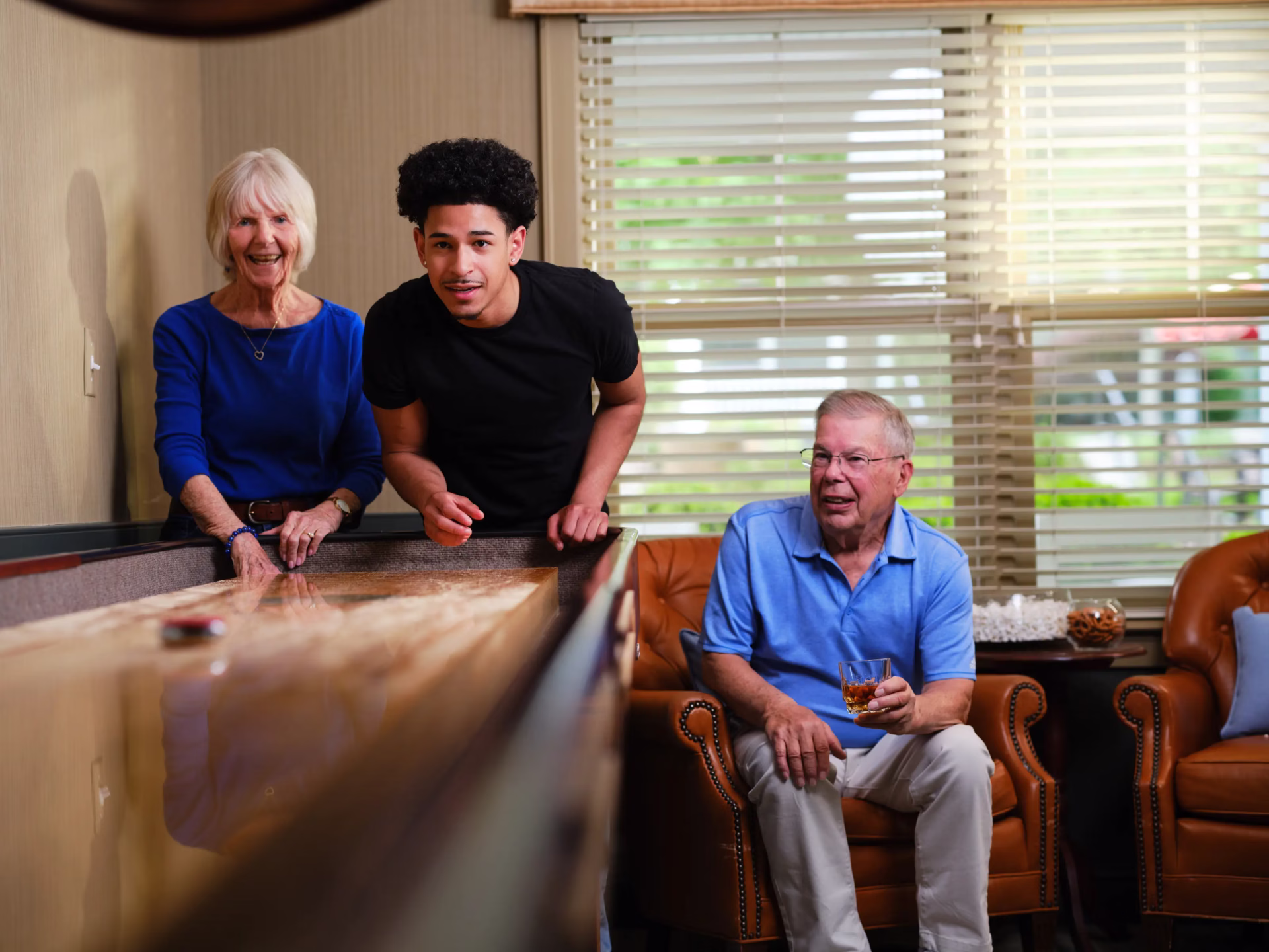 Residents and family playing indoor shuffleboard