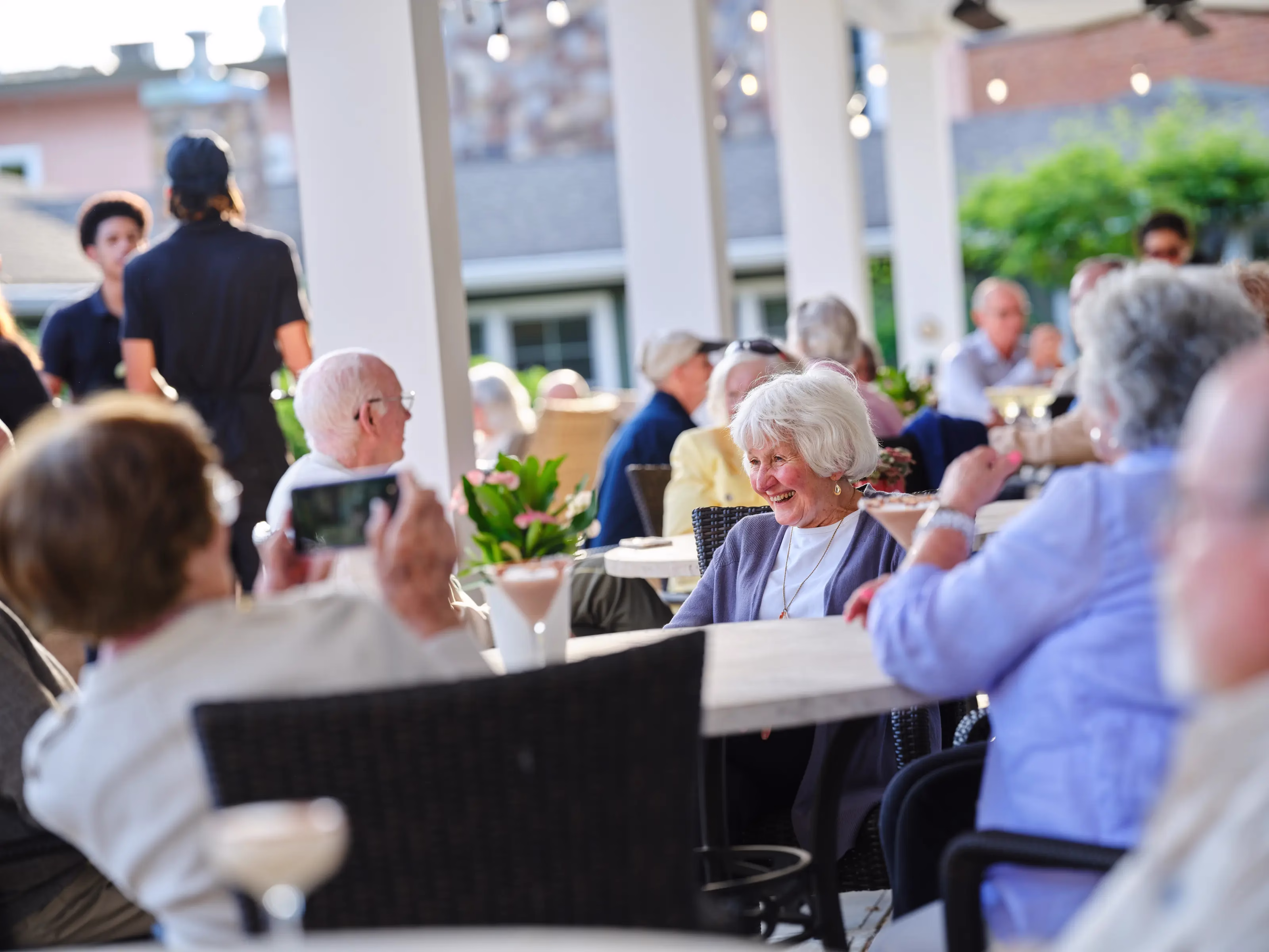 Residents at tables in outdoor patio