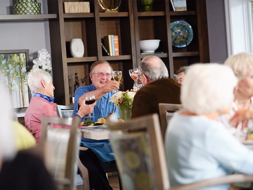 Residents sitting a indoor table with wine