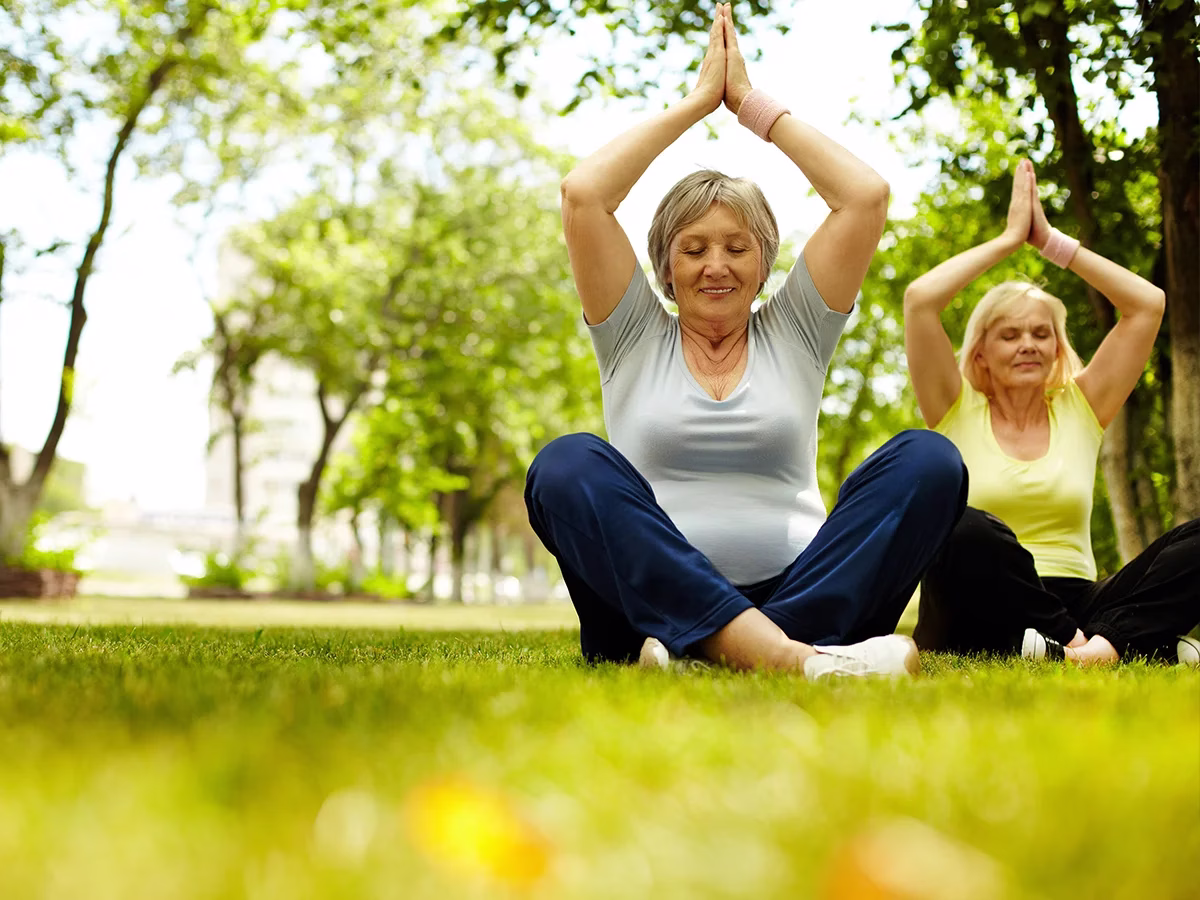 Residents practicing yoga outside on grass