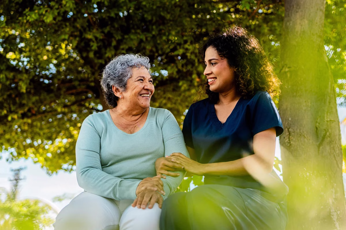 Woman and care giver sitting outside