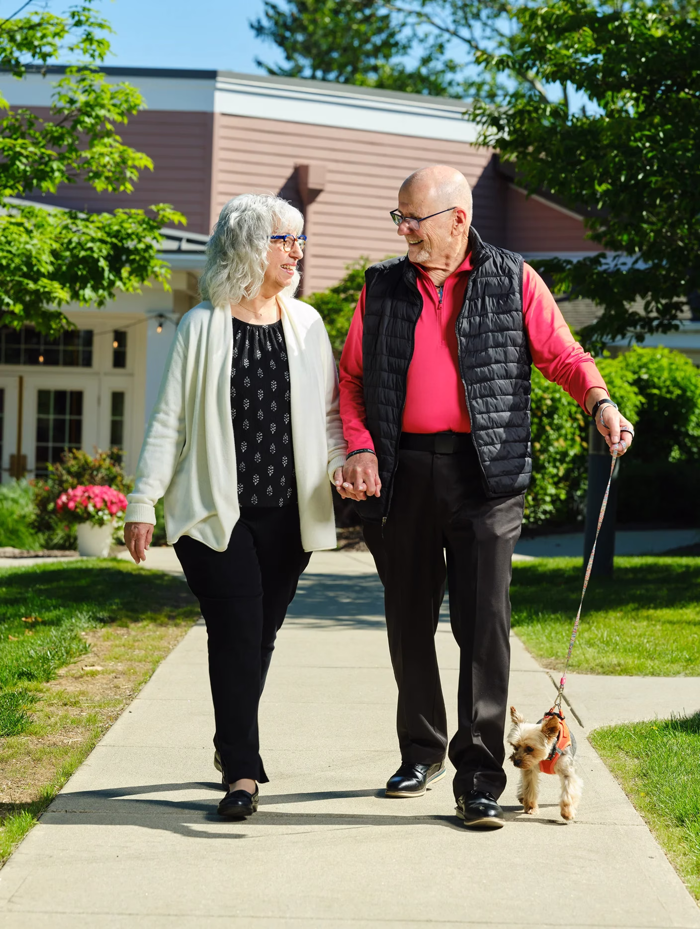Man and woman walking dog outdoors