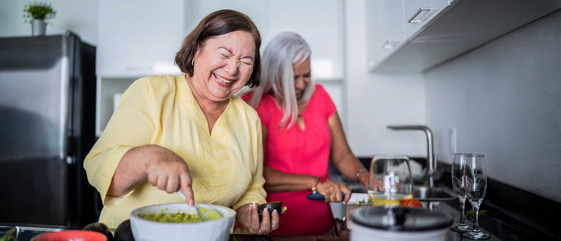Two women preparing food in kitchen